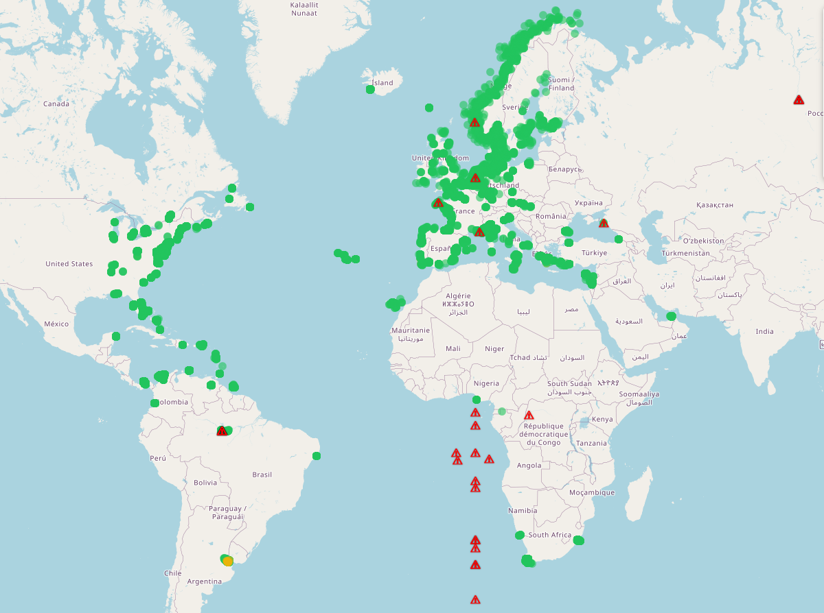 AIS monitoring map showing green valid vessel positions along coastlines and red glitch triangles scattered across Africa and inland areas